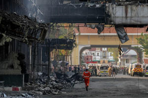 Des sauveteurs thaïlandais et cambodgiens se rassemblent devant l'hôtel casino Grand Diamond après un incendie qui a fait au moins 10 morts et des dizaines de blessés à Poipet