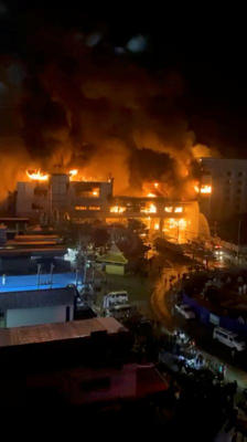 De la fumée et du feu s'élèvent des bâtiments après un incendie au Grand Diamond Casino, à Poipet