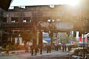Des soldats cambodgiens patrouillent dans la partie détruite de l'hôtel-casino Grand Diamond City après un incendie à Poipet, le 30 décembre 2022.