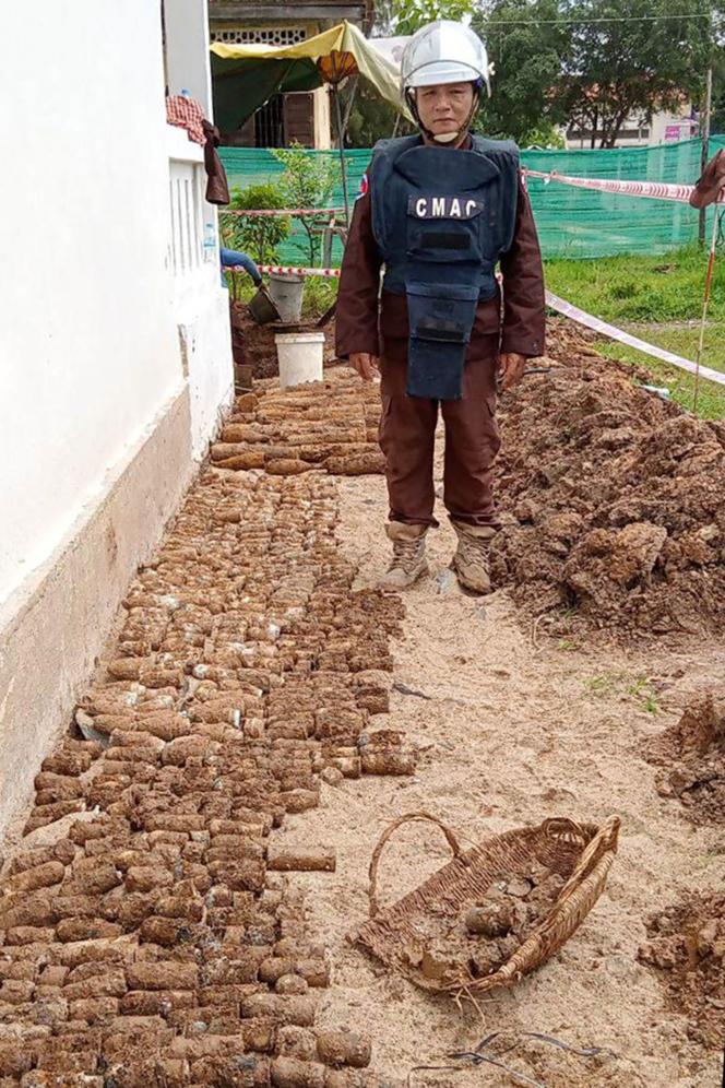 Un démineur se tient à côté de milliers de munitions non explosées datant de la guerre civile cambodgienne, après leur découverte dans un lycée de la province cambodgienne de Kratie (Cambodge), le 13 août 2013.